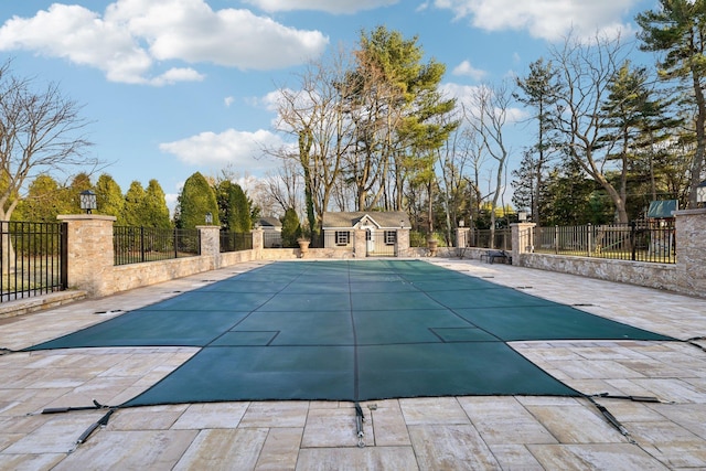 view of pool with a fenced in pool, a storage structure, fence, an outdoor structure, and a patio