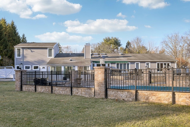 back of property featuring a patio area, a lawn, fence, and a chimney