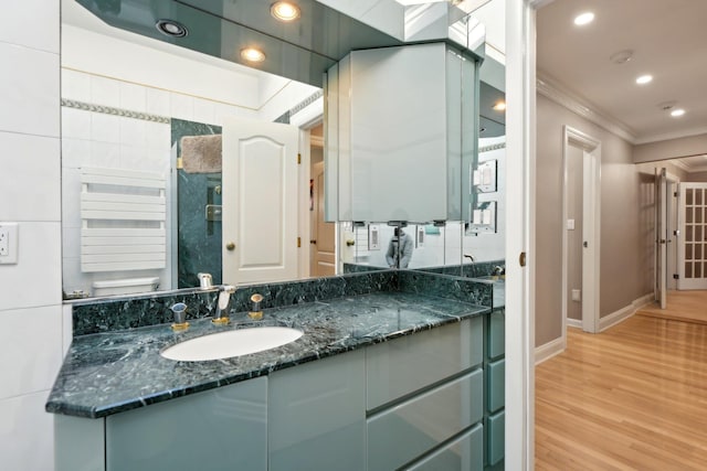 bathroom featuring vanity, wood finished floors, recessed lighting, ornamental molding, and toilet