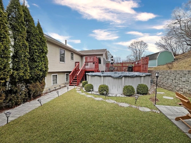 rear view of property featuring a deck, a yard, a fenced in pool, and fence