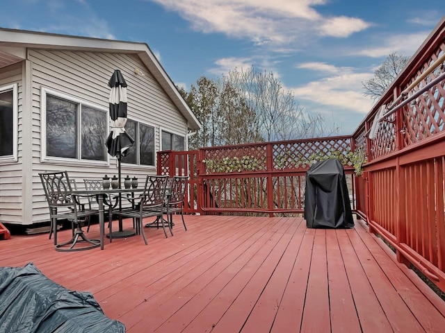 deck with outdoor dining area and a grill