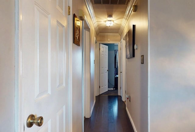 hall with dark wood finished floors, crown molding, visible vents, and baseboards