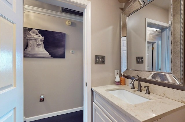 bathroom with vanity, visible vents, and baseboards