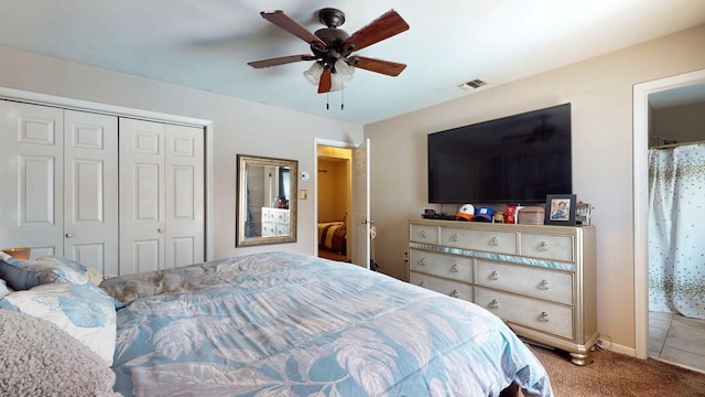 carpeted bedroom with a closet, visible vents, and ceiling fan