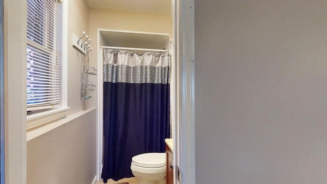 bathroom featuring a shower with shower curtain, toilet, and vanity