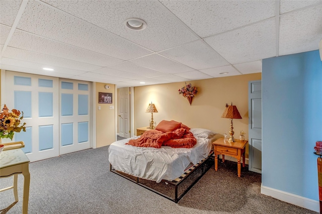 carpeted bedroom featuring recessed lighting, a closet, a drop ceiling, and baseboards