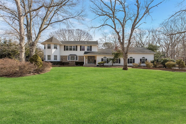 view of front of house featuring stone siding and a front yard