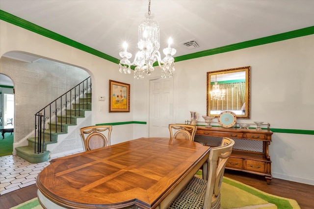 dining area featuring visible vents, crown molding, wood finished floors, and arched walkways