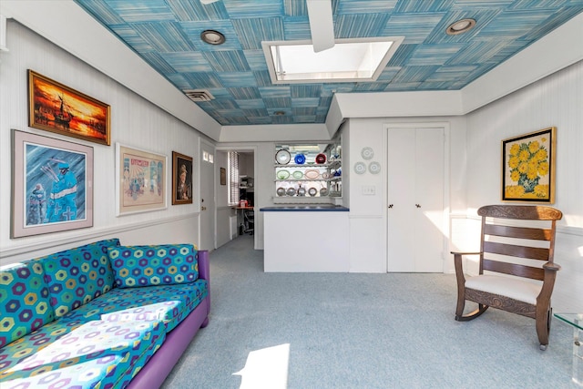 carpeted living room featuring a skylight