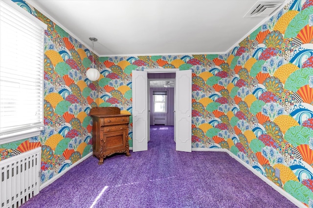 carpeted bedroom featuring radiator, baseboards, visible vents, wallpapered walls, and crown molding