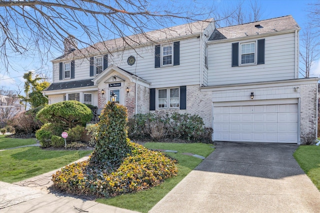 view of front of property featuring brick siding, concrete driveway, a front yard, a chimney, and a garage