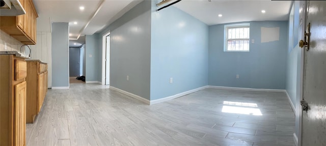 below grade area with recessed lighting, baseboards, and light wood-style floors