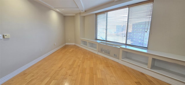 unfurnished room with baseboards and light wood-type flooring