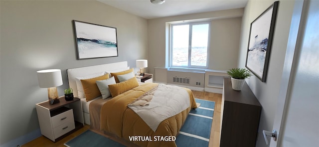 bedroom with wood finished floors, visible vents, and baseboards