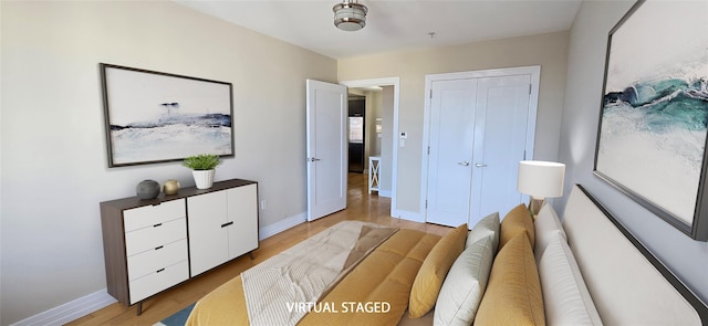 bedroom with a closet, baseboards, and light wood-style flooring