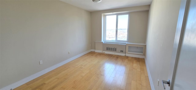 unfurnished room with baseboards, visible vents, and light wood finished floors