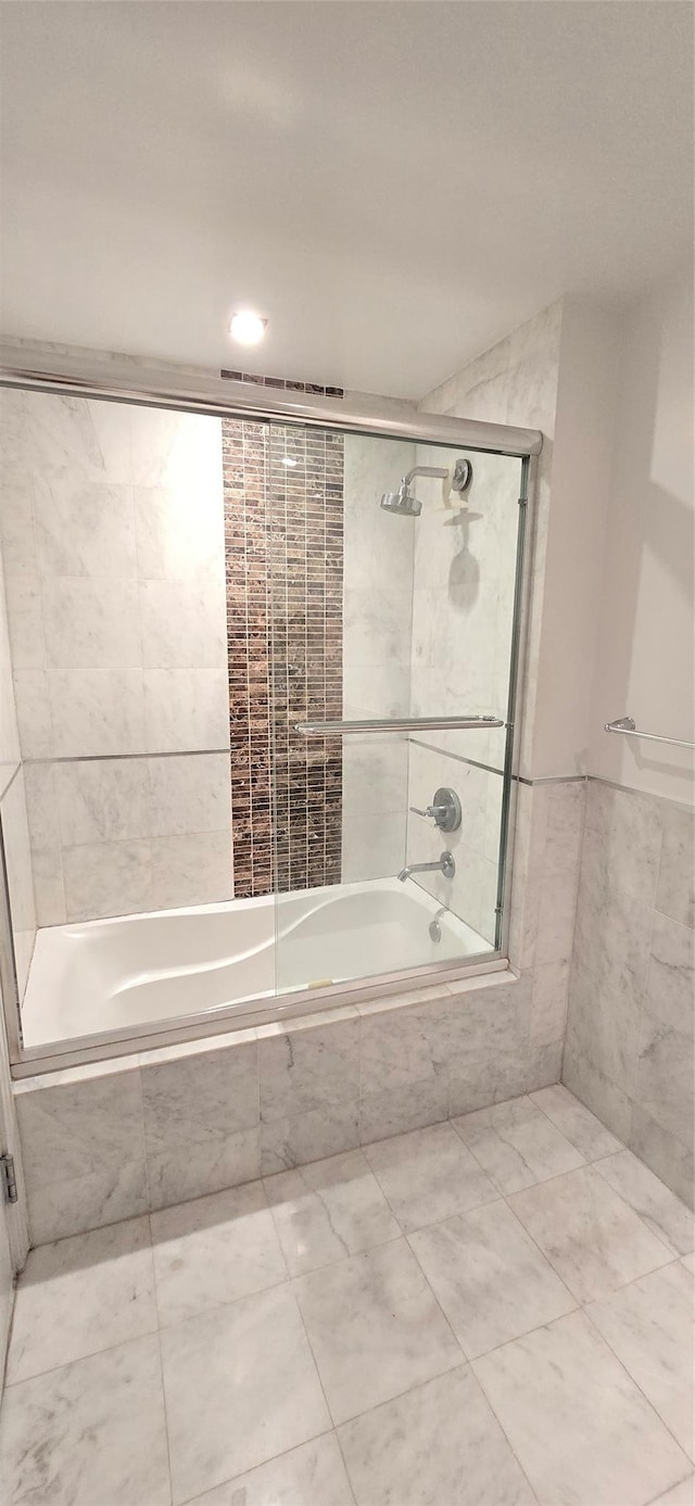 full bath with tile walls and tiled shower / bath combo