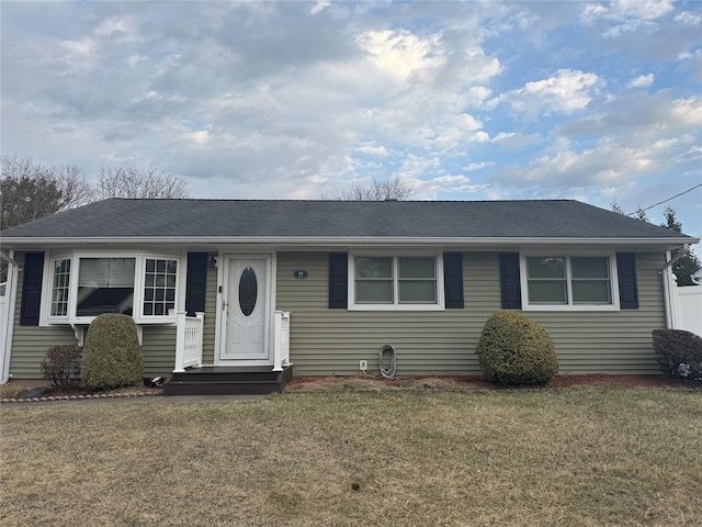 view of front of home with a front lawn and roof with shingles