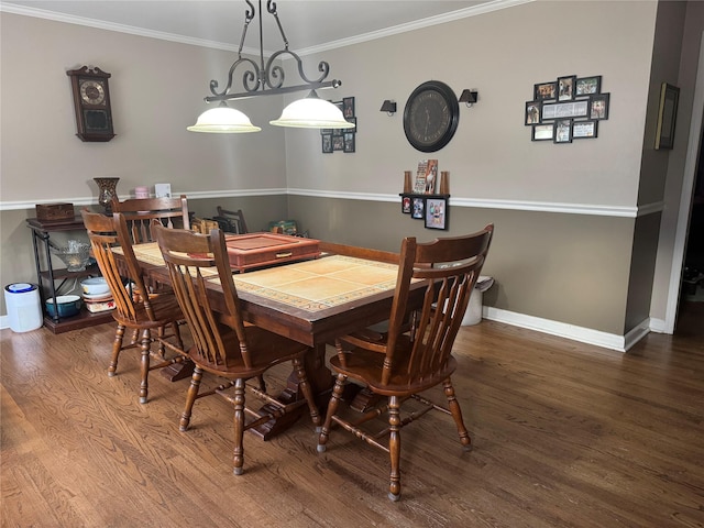 dining area with ornamental molding, baseboards, and wood finished floors