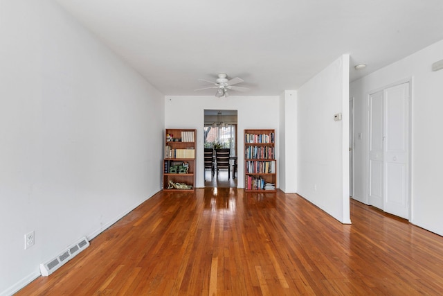 unfurnished room featuring visible vents, wood-type flooring, and ceiling fan