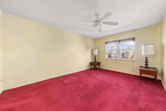 carpeted spare room with a ceiling fan