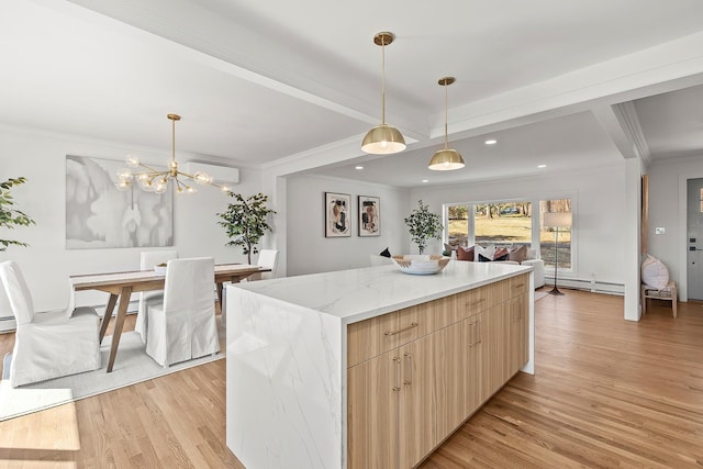 kitchen with a wall mounted AC, a baseboard heating unit, a kitchen island, crown molding, and light wood finished floors