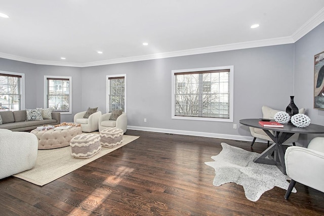 living area with baseboards, wood finished floors, and crown molding