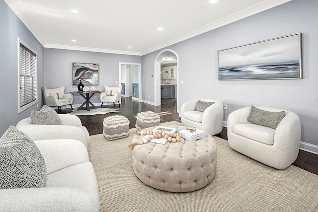 living room with wood finished floors, recessed lighting, arched walkways, crown molding, and baseboards