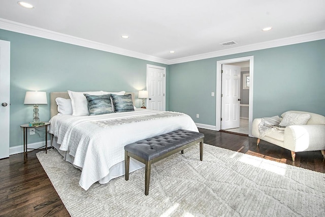 bedroom with wood finished floors, visible vents, and ornamental molding