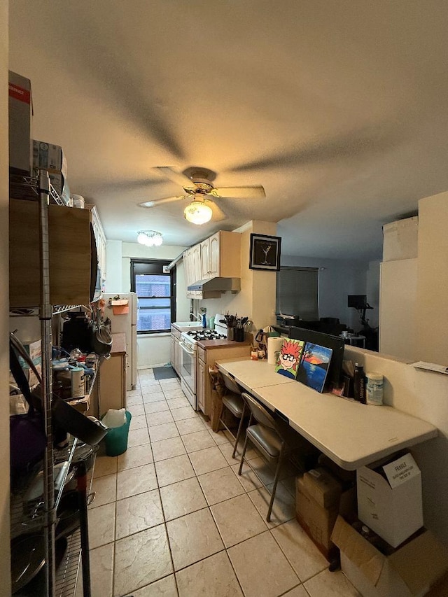 kitchen featuring ceiling fan, a textured ceiling, light tile patterned flooring, under cabinet range hood, and white gas range oven