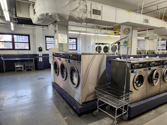 community laundry room with stacked washer / drying machine, visible vents, and separate washer and dryer