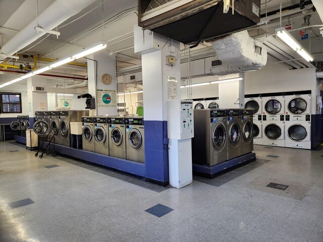 shared laundry area with washing machine and dryer, tile patterned floors, visible vents, and stacked washer / dryer