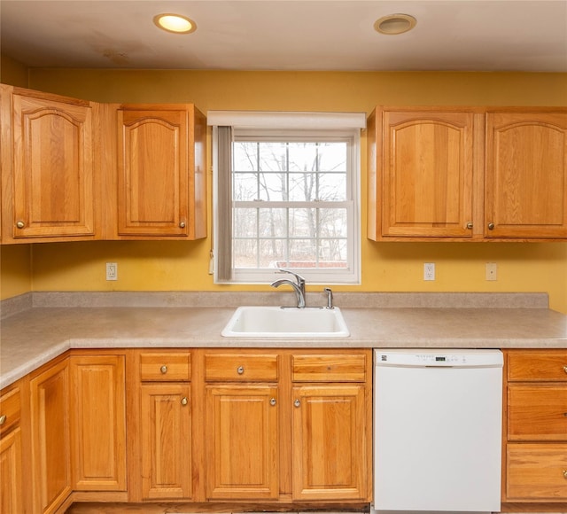 kitchen with a sink, light countertops, and white dishwasher