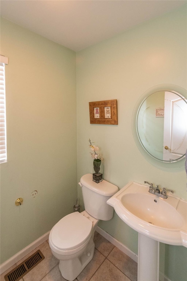 bathroom featuring tile patterned floors, toilet, baseboards, and visible vents