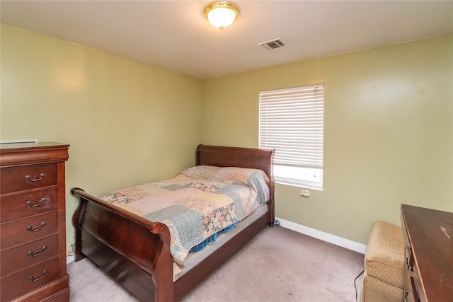 bedroom featuring visible vents, light colored carpet, and baseboards