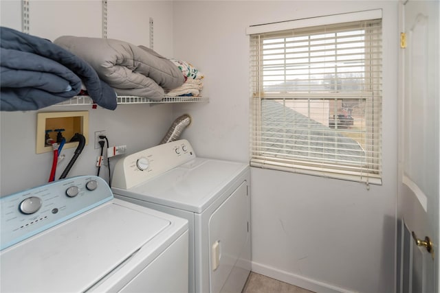 clothes washing area with laundry area, washing machine and dryer, and baseboards