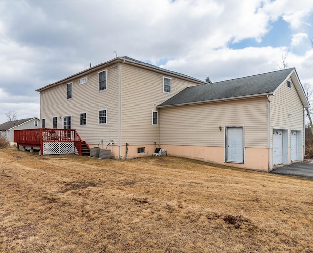 back of house with central AC unit, driveway, a garage, a deck, and a lawn