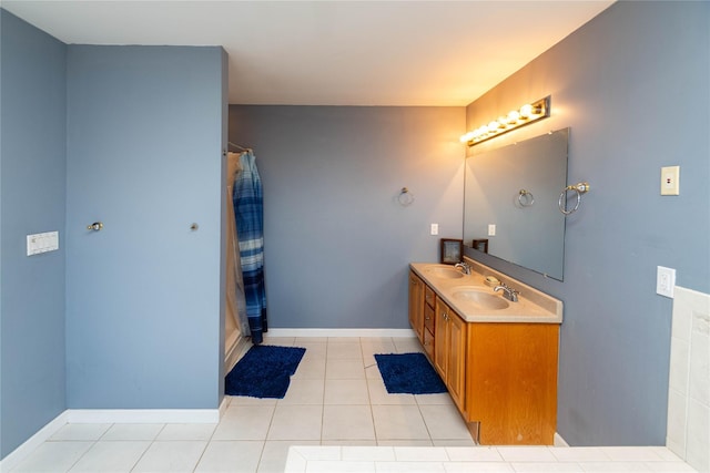 full bath featuring curtained shower, tile patterned floors, baseboards, and a sink