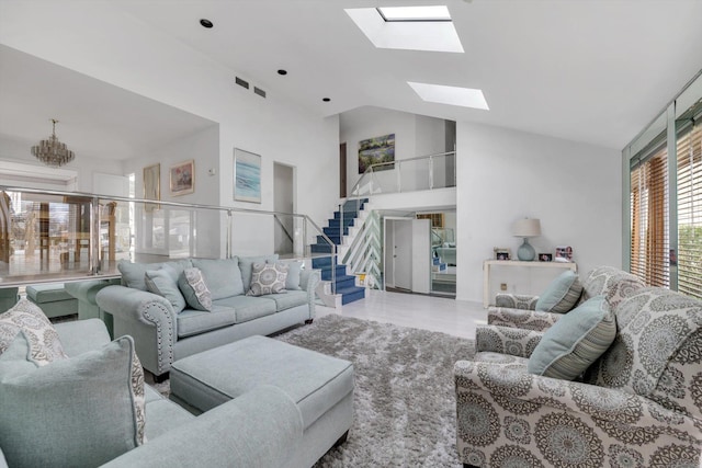 living area featuring stairs, a skylight, tile patterned flooring, and high vaulted ceiling