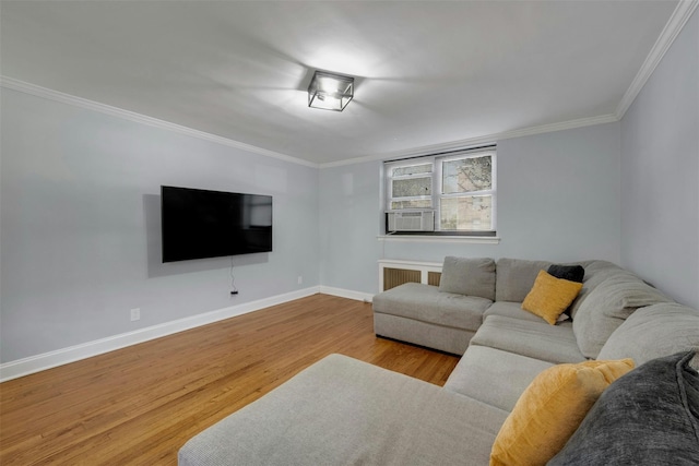 living area featuring radiator, baseboards, ornamental molding, cooling unit, and wood finished floors