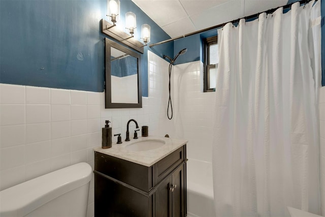 bathroom with vanity, tile walls, shower / bath combination with curtain, and toilet