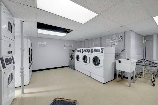 shared laundry area featuring washer and dryer, stacked washing maching and dryer, light floors, and a sink