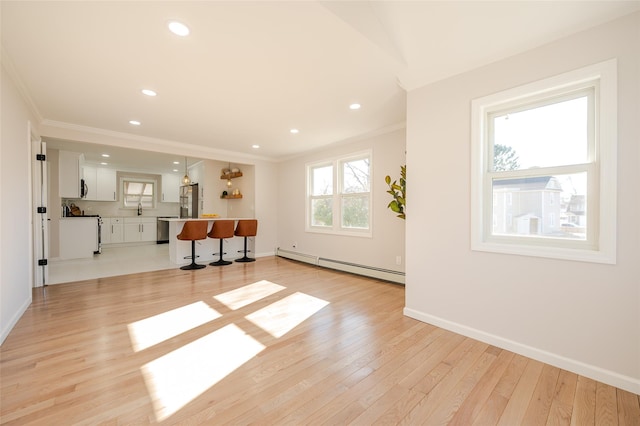 interior space with crown molding, baseboards, light wood-type flooring, and baseboard heating