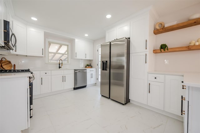 kitchen with marble finish floor, a sink, white cabinetry, stainless steel appliances, and light countertops