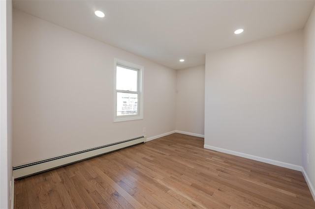 empty room with recessed lighting, baseboards, light wood finished floors, and a baseboard radiator