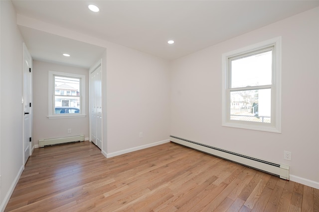 unfurnished room featuring recessed lighting, baseboards, baseboard heating, and light wood-style flooring