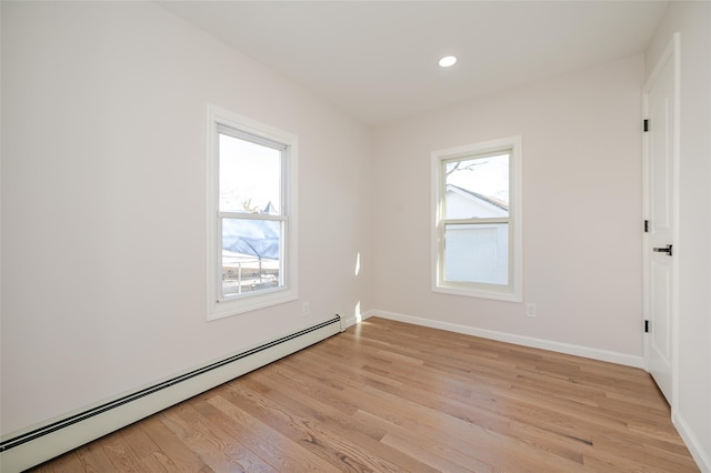 unfurnished room featuring baseboard heating, recessed lighting, baseboards, and light wood-style floors