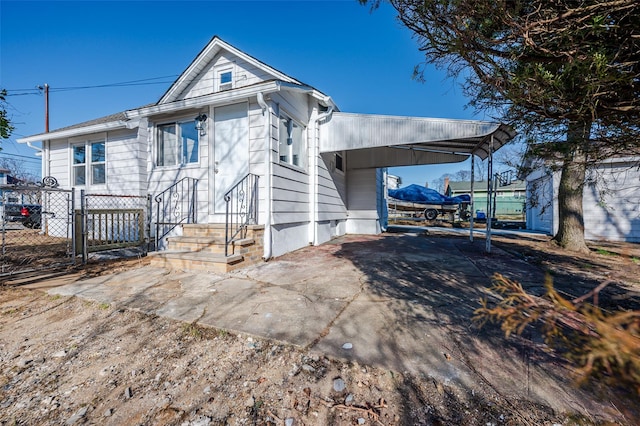 view of front of home with a carport, a gate, fence, and driveway