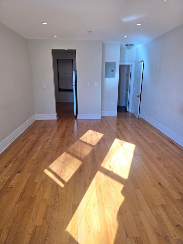 empty room featuring hardwood / wood-style floors, recessed lighting, and baseboards