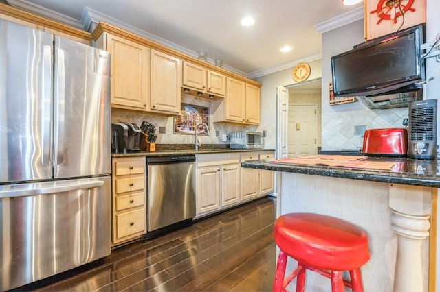 kitchen featuring light brown cabinets, dark wood-style flooring, decorative backsplash, appliances with stainless steel finishes, and crown molding